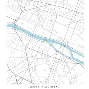 May include: A custom map print featuring a black and white street grid of Paris with a light blue river flowing through the center. A small circular marker highlights a specific location. Text reads: WHERE IT ALL BEGAN, Sophie & Lucas, PARIS, MAY 18, 2019.