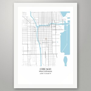 May include: A framed map print of Chicago featuring black street grids and light blue water elements. A small red circle marks a specific location. Below the map, the text reads: CHICAGO, Where it all started, 41.8781&deg; N, 87.6298&deg; W.