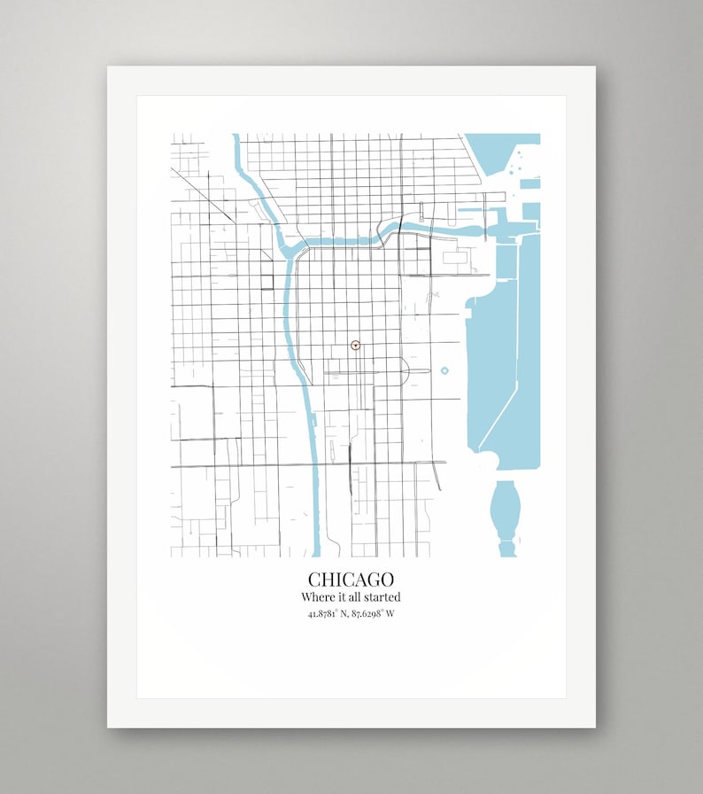 May include: A framed map print of Chicago featuring black street grids and light blue water elements. A small red circle marks a specific location. Below the map, the text reads: CHICAGO, Where it all started, 41.8781&deg; N, 87.6298&deg; W.