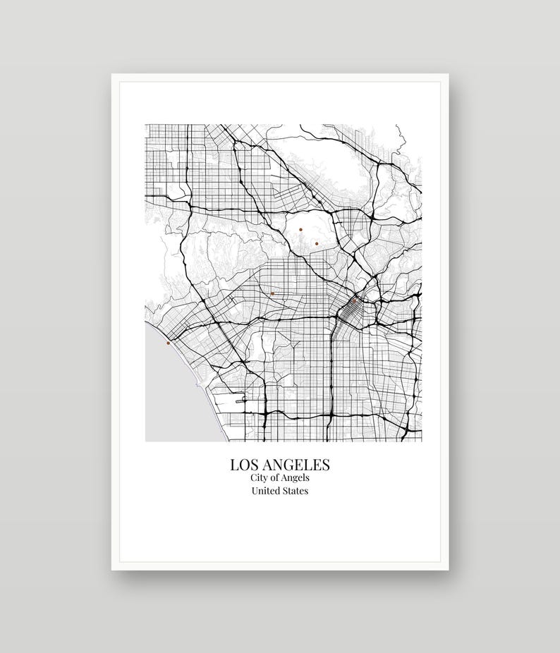 May include: A framed map print of Los Angeles, California, featuring a black and white street grid with thin gray lines and thick black highway lines. The text below the map reads LOS ANGELES, City of Angels, United States in black font.