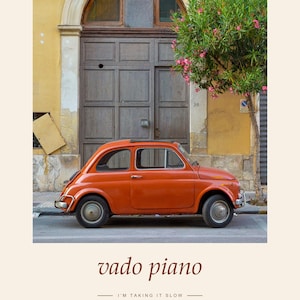 May include: A vintage orange compact car parked in front of a brown wooden door and a yellow building wall. The text "SICILIA ITALIA" appears at the top, while the text "vado piano" and "I'M TAKING IT SLOW" are printed at the bottom.