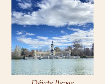 May include: A print featuring the Estanque del Retiro in Madrid with a large lake, the Alfonso XII monument, and small boats under a bright blue sky with white clouds. The text reads Estanque del Retiro Madrid, Déjate llevar, and Let yourself go.