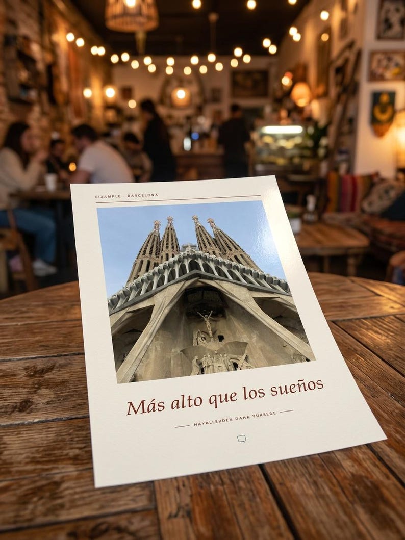 K&ouml;nnte beinhalten: Ein rechteckiger Druck mit einer Froschperspektive der Basilika Sagrada Familia in Barcelona. Der Text EIXAMPLE BARCELONA steht oben, w&auml;hrend der spanische Satz M&aacute;s alto que los sue&ntilde;os und ein t&uuml;rkischer Text darunter gedruckt sind.
