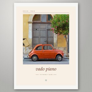 May include: A framed wall art print featuring a vintage orange car parked in front of a brown wooden door and a yellow building. The text reads SICILIA ITALIA, vado piano, and I'M TAKING IT SLOW, with a small speech bubble icon at the bottom.