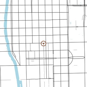 May include: A minimalist map illustration featuring a grid of thin black lines representing city streets, a light blue vertical band indicating a river on the left, and a single brown circular marker with a central dot in the middle.
