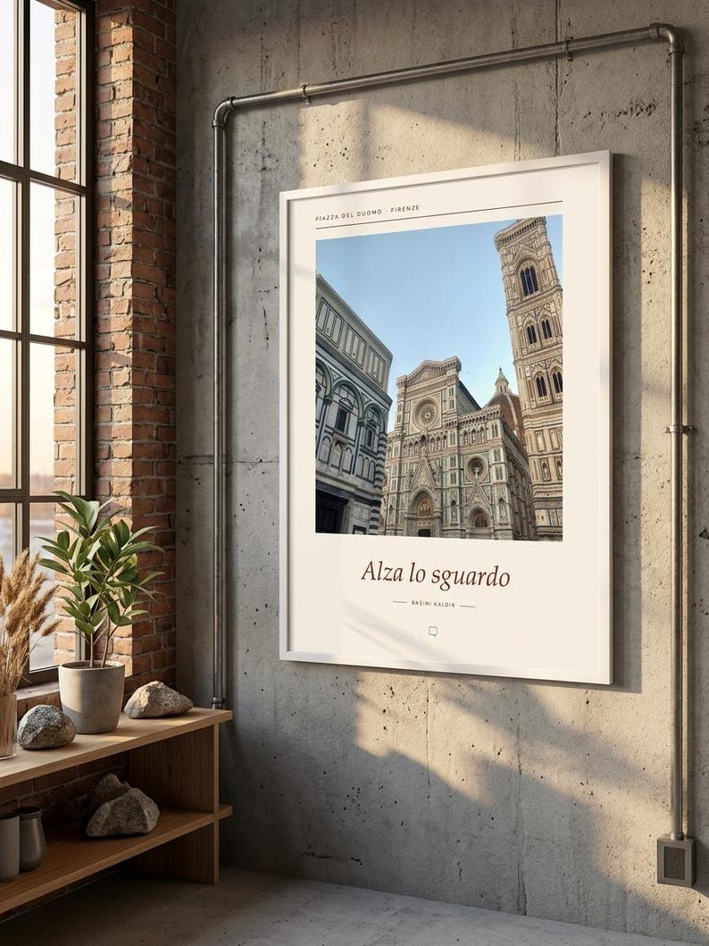 Puede incluir: Un cuadro rectangular con marco blanco que muestra una fotograf&iacute;a de la Piazza del Duomo en Florencia, Italia. La impresi&oacute;n incluye el texto "PIAZZA DEL DUOMO FIRENZE" en la parte superior y "Alza lo sguardo" con "BASINI BALDINI" debajo.