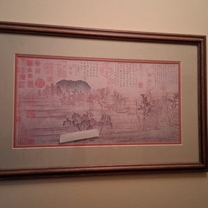 Rouleau imprimé de paysage chinois encadré, orné de sceaux rouges et de calligraphie.