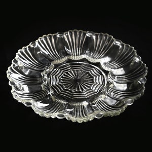 May include: A clear glass serving dish with a scalloped edge and a central section divided into four smaller sections.