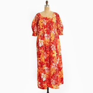 May include: A set of three ceramic mugs with a speckled, cream-colored glaze. Each mug features a different hand-painted floral design in shades of blue, green, and yellow. The mugs have a simple, modern shape.