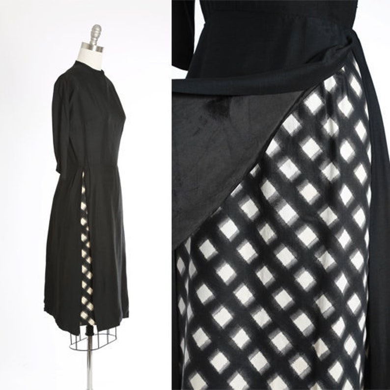 Puede incluir: Un vestido negro con un patr&oacute;n de cuadros blancos y negros en la falda. El vestido tiene un cuello alto y mangas largas.
