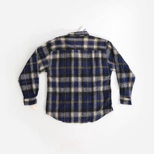 May include: A blue, black, and white plaid flannel shirt with long sleeves.