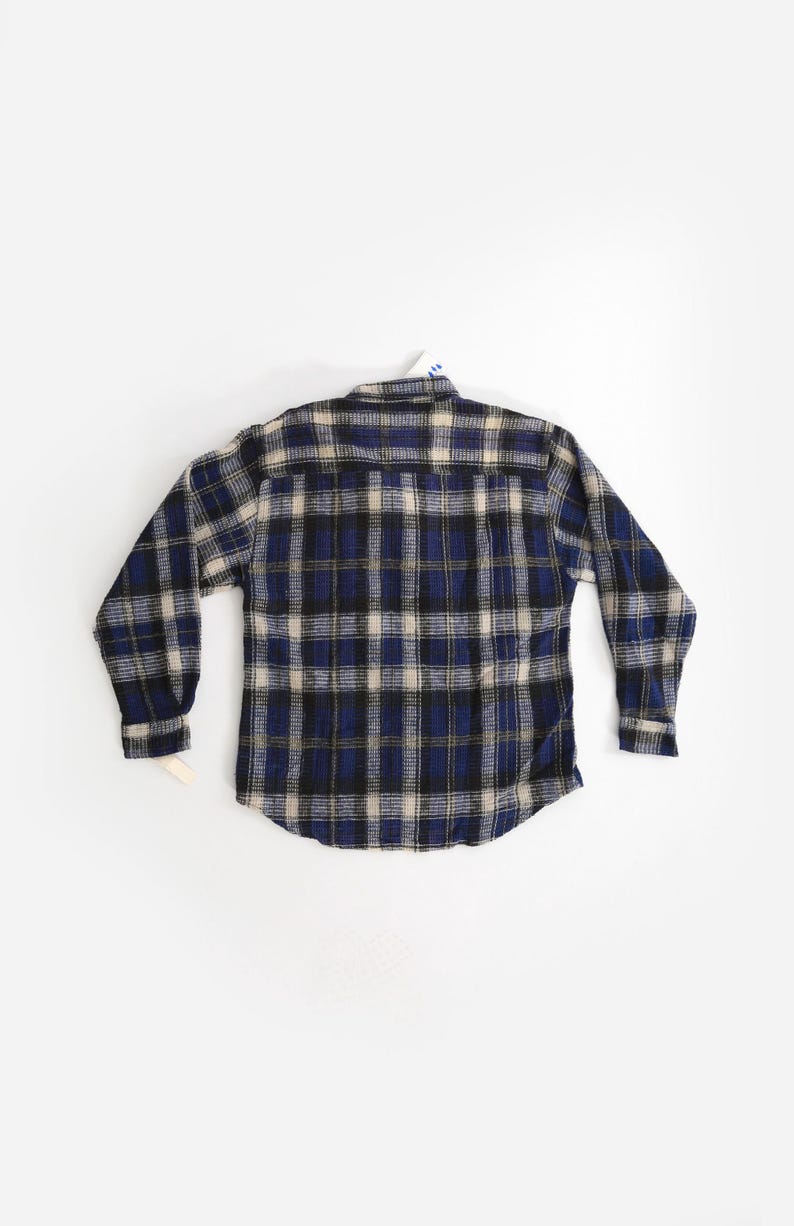 May include: A blue, black, and white plaid flannel shirt with long sleeves.