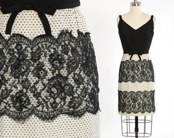 May include: A black and white sleeveless dress with a lace overlay and a polka dot pattern. The dress has a fitted bodice and a full skirt.