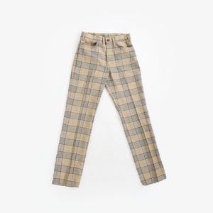 Peut inclure: Pantalon à carreaux beiges et gris, de coupe droite classique. Le pantalon est doté d'une fermeture boutonnée et zippée, de passants de ceinture et de poches. Le motif à carreaux est dans des tons neutres.