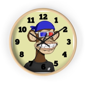 Puede incluir: Un reloj de pared redondo con marco de madera clara que presenta un mono de dibujos animados con un pañuelo azul y gafas 3D rojas y azules. El mono tiene una amplia sonrisa, viste una camiseta negra y está sobre un fondo amarillo pálido con números negros.