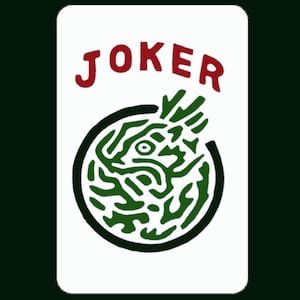 May include: A white playing card with the word "JOKER" printed in red letters. The card features a green and black circular design with a swirling pattern.