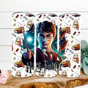 Puede incluir: Un vaso cilíndrico con un estampado gráfico de un joven mago con gafas redondas, una varita y una bufanda roja y dorada. El patrón incluye búhos blancos, libros, plumas y gafas. El texto Harry Potter está impreso en una fuente oscura.
