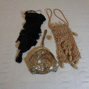 May include: Three vintage purses: a black beaded bag, a gold mesh bag, and a crocheted beige bag with a floral design.