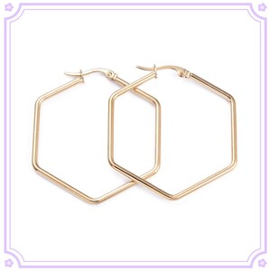 May include: A pair of gold hexagonal hoop earrings. The earrings are simple and elegant, and would make a great addition to any jewelry collection.