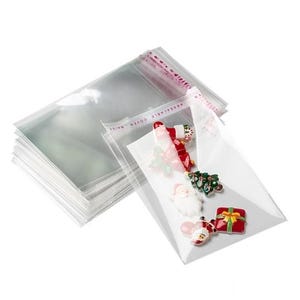 May include: Clear cellophane bags with a resealable top, stacked and filled with Christmas-themed embellishments. The bags contain miniature Santa Claus, Christmas tree, and gift box decorations.