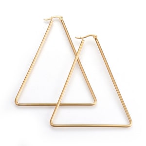 May include: A pair of gold triangle hoop earrings. The earrings are made of a thin metal wire and have a simple, geometric design.