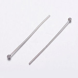 May include: Two silver head pins with a round ball head. The head pins are straight and have a shiny finish.