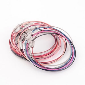 May include: A set of colorful metal keychains with silver clasps. The keychains are arranged in a circle and are made of thin, flexible metal.