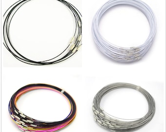 May include: A set of 10 stainless steel necklaces in various colors, including black, white, silver, and multi-colored. The necklaces are all the same length and have a simple, elegant design.