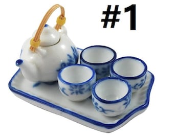 May include: A miniature porcelain tea set with a blue and white floral design. The set includes a teapot with a handle, four teacups, and a tray. The teapot has a bamboo handle. #1
