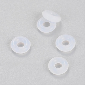 May include: Five white silicone rings, each with a hole in the centre. The rings are arranged in a semi-circle on a grey surface.