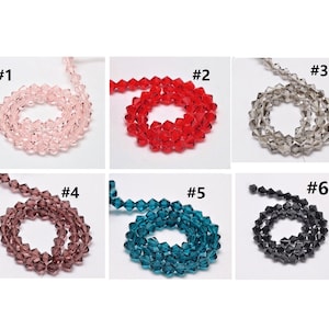 May include: Six strands of faceted glass beads in various colours, including pink, red, clear, purple, teal, and black. Each strand is labelled with a number from 1 to 6.