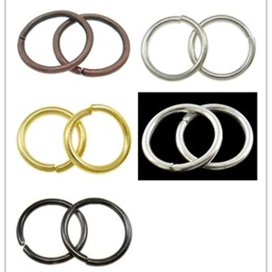 Peut inclure: Quatre paires d'anneaux de saut en métal dans différentes finitions : laiton antique, argent, or et noir. Chaque paire est composée de deux anneaux reliés entre eux.