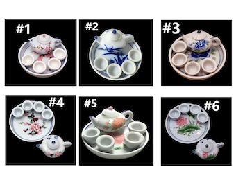 May include: Six miniature porcelain tea sets with different floral designs. Each set includes a teapot and six cups on a small plate. The sets are numbered 1 through 6.