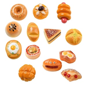 May include: A selection of miniature baked goods, including a donut, a bun with a black seed topping, a bread roll, a sandwich, and a pastry with a cherry topping. The items are in various shades of brown and orange.