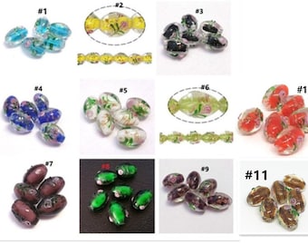 May include: Eleven different styles of oval glass beads with floral designs. The beads are translucent and have a variety of colors, including blue, yellow, green, red, and brown.