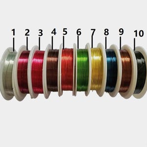May include: Ten spools of colorful wire, numbered 1 through 10, are arranged in a row. The wire colors are silver, burgundy, red, brown, orange, green, gold, blue, copper, and black.
