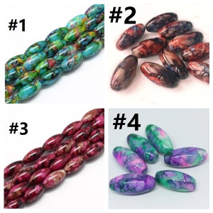 May include: Four sets of oval-shaped beads with different color patterns. Set #1 is turquoise with yellow and green swirls. Set #2 is red with black and white swirls. Set #3 is pink with black and white swirls. Set #4 is purple and green with pink swirls.
