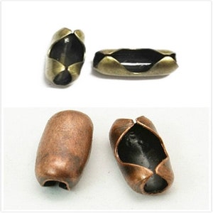May include: Two sets of metal chain end stoppers. One set is antique brass with a black interior. The other set is copper with a black interior.