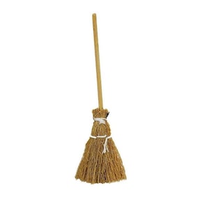 May include: A small decorative broom with a long, light brown wooden handle. The broom head is made of bundled straw, tied with white string. The broom is designed for decorative purposes.