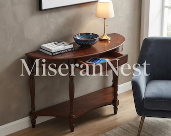May include: A semi-circular wooden console table with a dark brown finish, featuring four turned legs, a lower shelf, and a single pull-out drawer. The tabletop holds a blue ceramic bowl, two stacked books, and a small lamp with a beige shade.