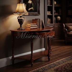 May include: A semi-circular wooden console table with a single pull-out drawer, featuring four fluted legs and a lower shelf. A table lamp with a fringed shade and a stack of four leather-bound books sit on top. The text Miseran Nest is visible.