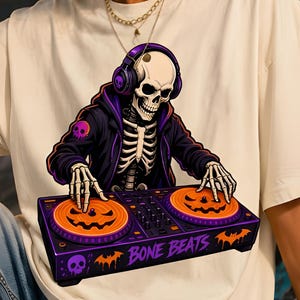May include: An off-white t-shirt featuring a graphic of a skeleton wearing purple headphones and a black hoodie. The skeleton is DJing on a purple console with orange jack-o'-lantern platters. The text BONE BEATS is printed on the console.