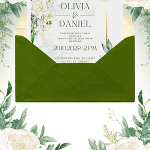 May include: A wedding invitation card inside a dark green envelope, featuring a gold arch frame, white floral illustrations, and the text: OLIVIA & DANIEL, TOGETHER WITH THEIR FAMILIES INVITE YOU TO JOIN THEIR WEDDING 20.10.2029 2 PM 123 ANYWHERE ST., ANY CITY, ST 12345.