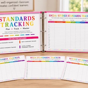 May include: A pink three-ring binder open to a Social Studies Standards Tracker page, accompanied by three loose-leaf tracking sheets for ELA, Math, and Science. Each page features colorful headers, numbered rows, and columns for tracking student mastery.