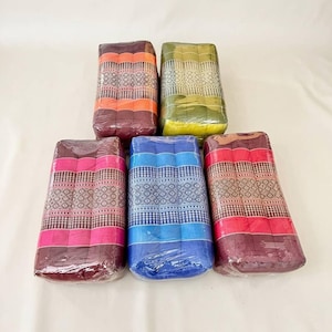 May include: Five rectangular Thai-style cushions wrapped in clear plastic. Each cushion features a distinct color including orange, green, pink, blue, and red, all decorated with a central band of intricate geometric patterns and vertical stitching.