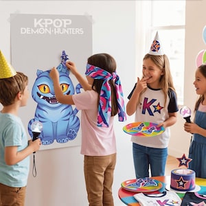 May include: A KPOP Demon Hunters party game set featuring a large poster of a blue cat, a colorful blindfold, party hats, plates with graphic prints, and light-up wands. The poster displays the text KPOP DEMON HUNTERS in white lettering.