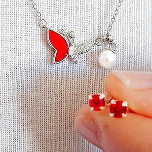 Conjunto de joyas de mariposa esmaltada en plata de ley, collar y pendientes de perlas y rubíes.