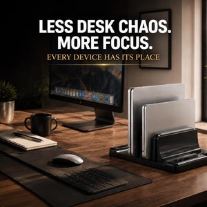 Puede incluir: Un soporte vertical negro para portátil que sostiene dos portátiles plateados, con el texto LESS DESK CHAOS. MORE FOCUS. EVERY DEVICE HAS ITS PLACE. El soporte está sobre un escritorio de madera junto a un monitor, un cuaderno y un ratón.