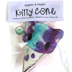 Puede incluir: Un juguete de gato de felpa en forma de cono de helado, con estampado tie-dye morado y azul. El juguete est&aacute; hecho a mano con felpa, hierba gatera org&aacute;nica y relleno de fibra. El juguete tiene una etiqueta USDA Organic.