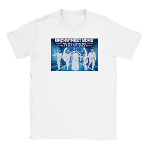 Könnte beinhalten: Ein weißes T-Shirt mit kurzen Ärmeln und einem zentralen Grafikdruck der Backstreet Boys. Das Bild zeigt fünf Personen in weißen Outfits in einem blauen Tunnel, mit dem Text BACKSTREET BOYS HOMECOMING GERMANY 2026 darüber.